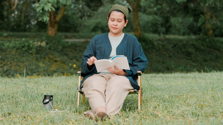 Woman sitting in a field reading