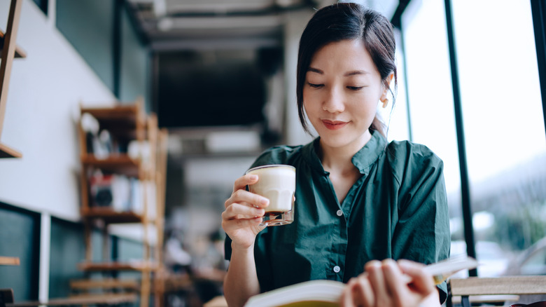 Woman reading book in coffee shop