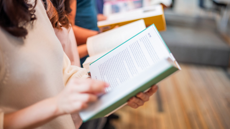 A woman holding a book open and reading