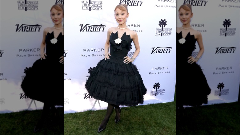 Ariana Grande wearing a black dress with a ruffled, knee-length skirt to Variety's 0 Directors To Watch and Creative Impact Awards