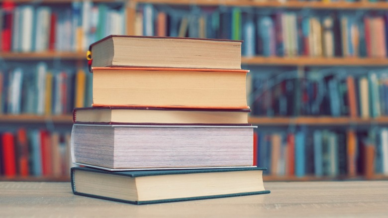 A stack of books on a table in a library