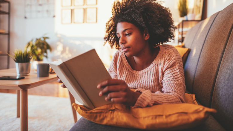 Woman reading a book on a sofa