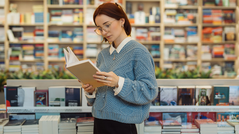 Woman reading a book in store