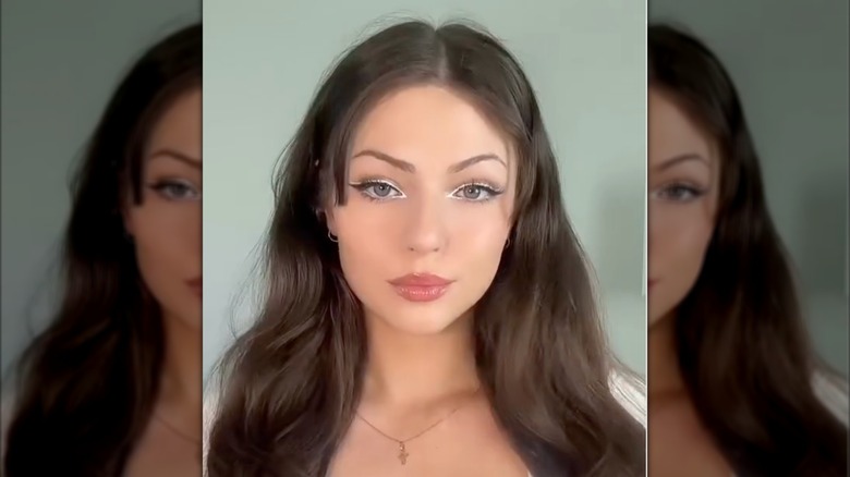 A brunette woman with white eyeliner in a video on Instagram
