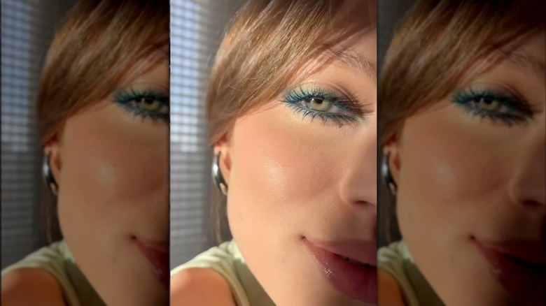 A woman with sage green eyeliner on