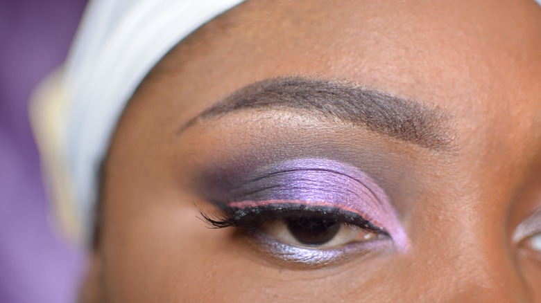 Dark skinned woman wearing purple eyeshadow