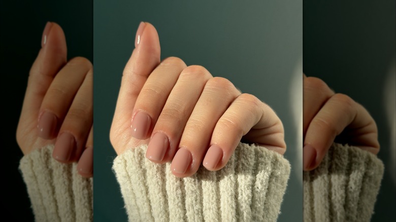 A woman shows off her nude pink nails