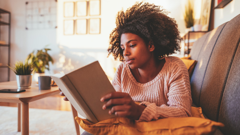 Woman reading book on the couch