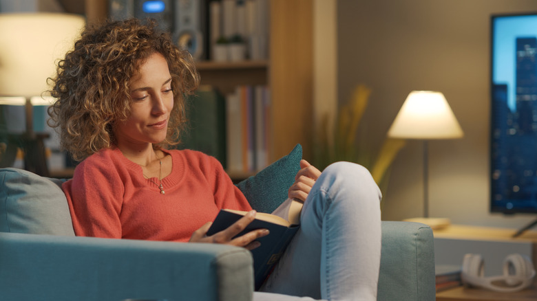 Woman reading a book on a chair