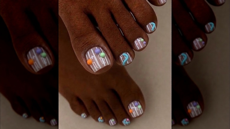 A woman with 3D nail shapes in bright colors