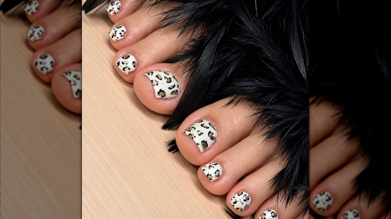 A close up of a pedicure in gold and black animal print