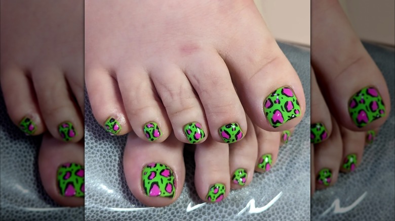 A woman with neon pink and green animal print toes