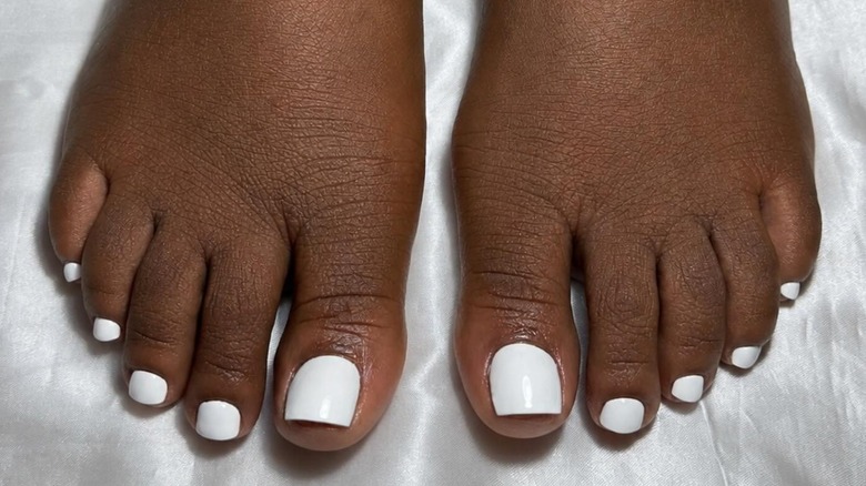 A woman's feet with a white pedicure