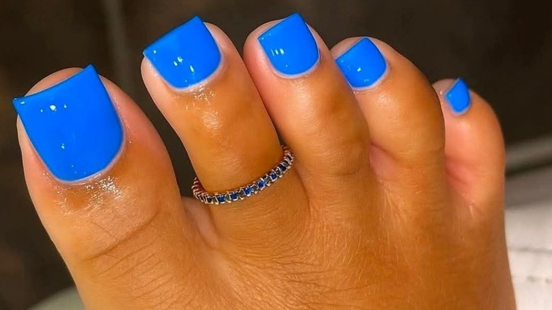 A foot with a cobalt blue pedicure