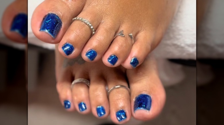 Two feet with a blue pedicure