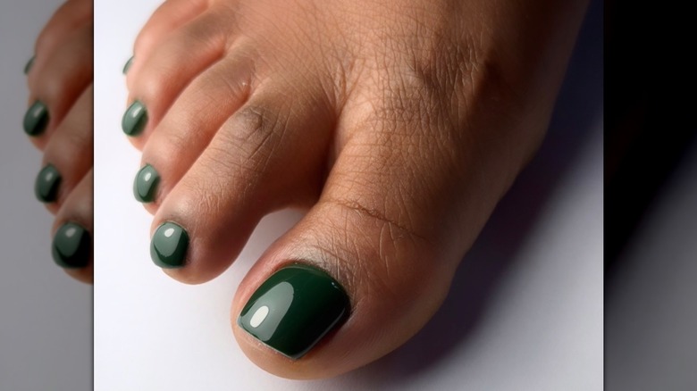 A foot with an emerald green pedicure