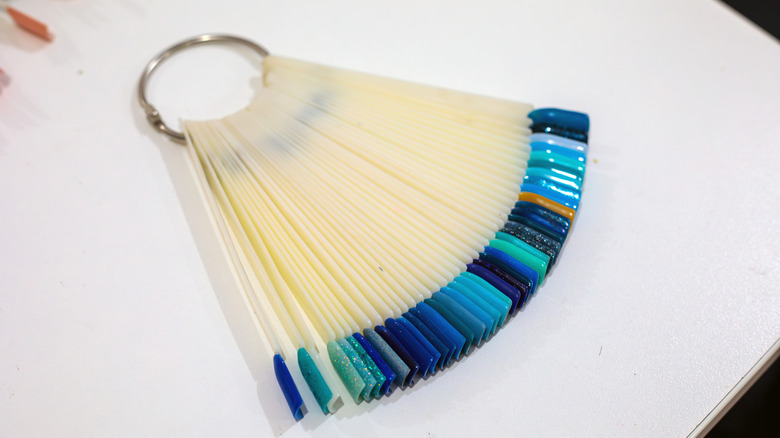 maincure gel color ring on white table with range of blue shades