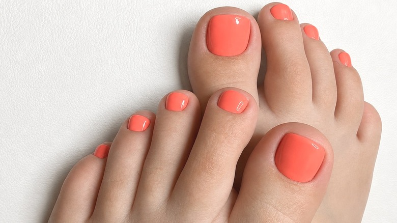 Two feet with a soft coral pedicure