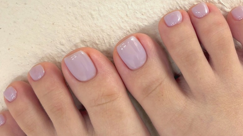 Feet with a cool-toned lavender pedicure