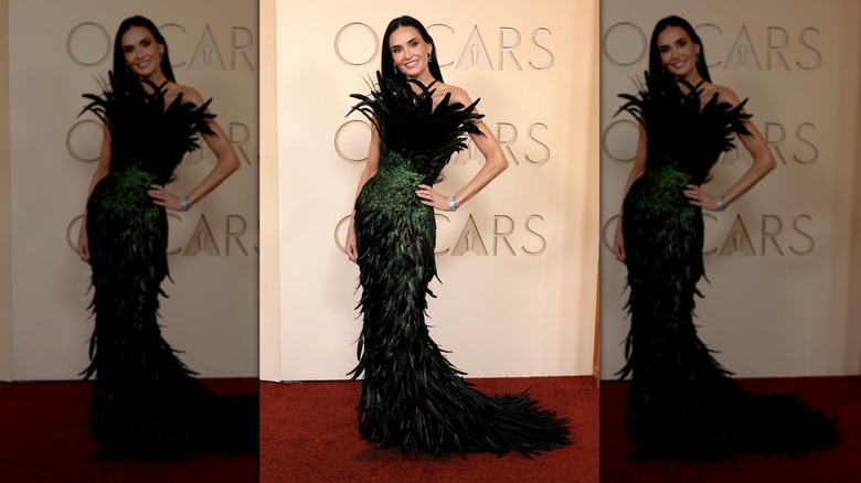 Demi Moore on the red carpet in a black and green feathered dress