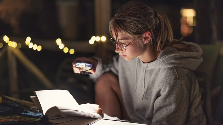 Woman reading book at night
