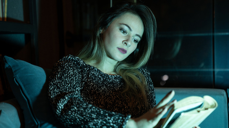 Woman reading creepy book on a couch