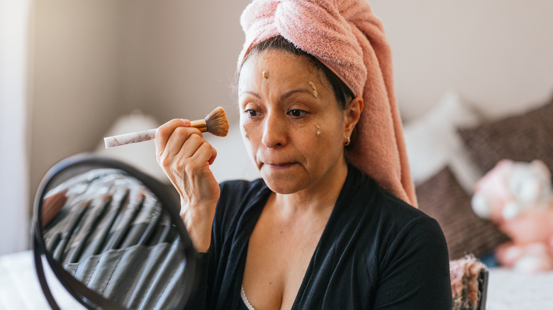 Older woman applying foundation