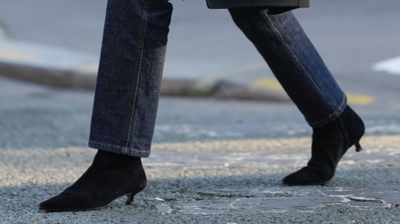 A woman wearing black ankle boots with stovepipe jeans