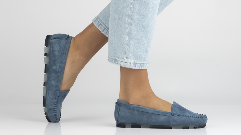 A person wearing light stovepipe jeans with loafers