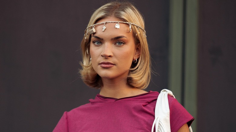 A woman in a pink shirt with a dangling headband