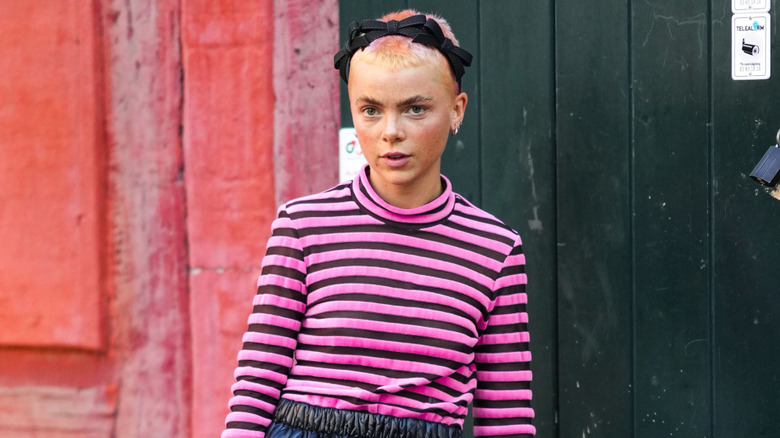 A woman with blonde and pink pixie cut hair with a black headband