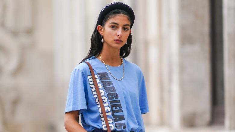 A young woman wearing a dark headband with a blue shirt