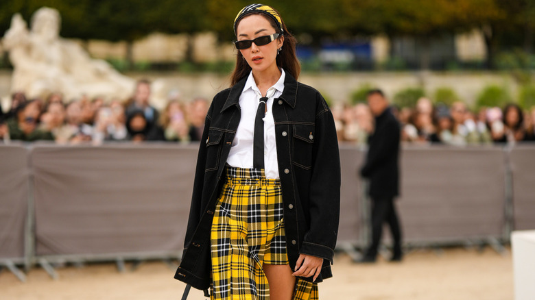 A woman wearing a plaid headband and matching skirt