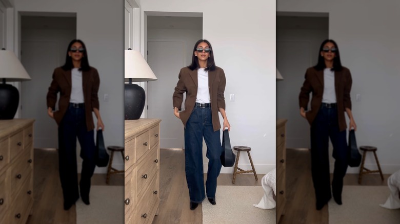 A woman wearing dark flared jeans and a brown blazer