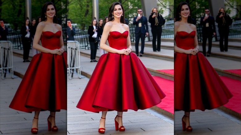 Anne Hathaway smiling in a strapless red gown at "The Devil Wears Prada 2" world premiere