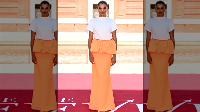 Simone Ashley in a T-shirt and orange peplum skirt during a London photocall for "The Devil Wears Prada 2"