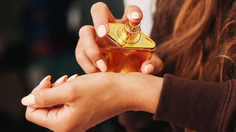 A woman spraying perfume on her wrist
