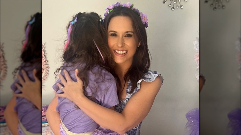 Lacey Chabert smiling while holding her daughter