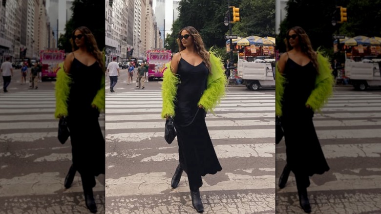 A woman wearing a black dress with a lime green sweater