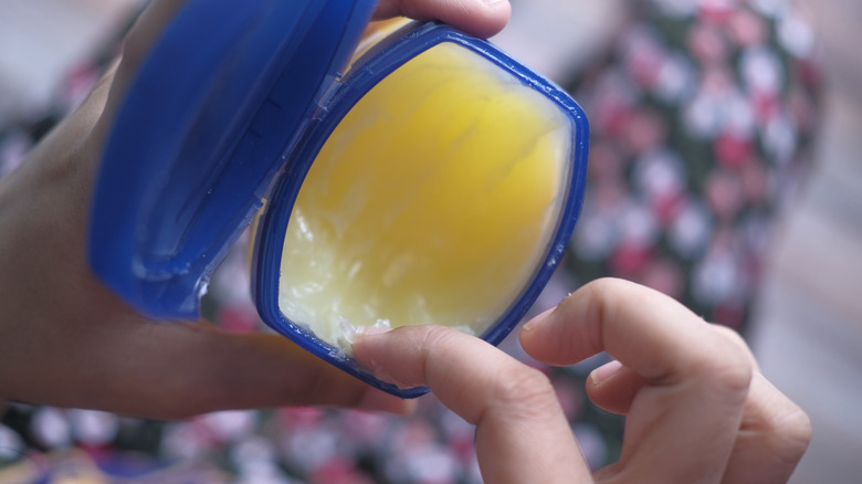 Woman grabbing petroleum jelly