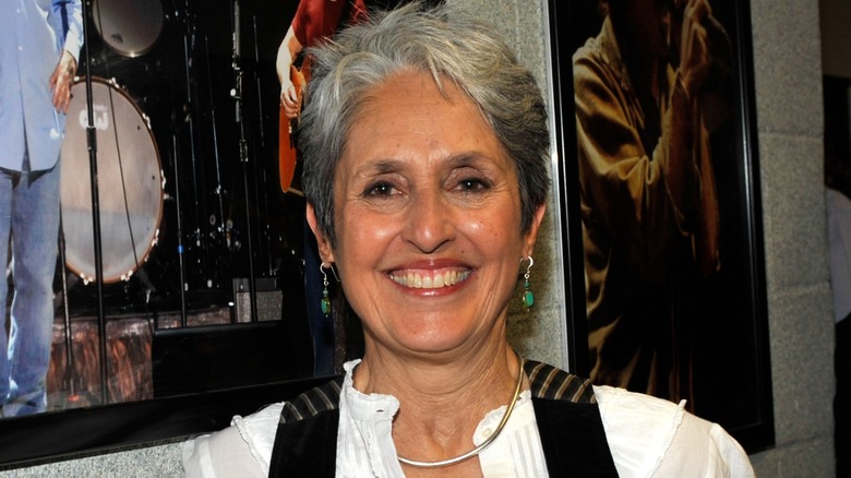 Joan Baez smiling backstage at an event 2009 in a white shirt
