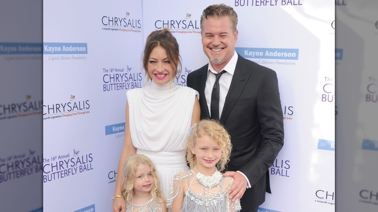 Rebecca Gayheart and Eric Dane smiling on the red carpet with their two young daughters