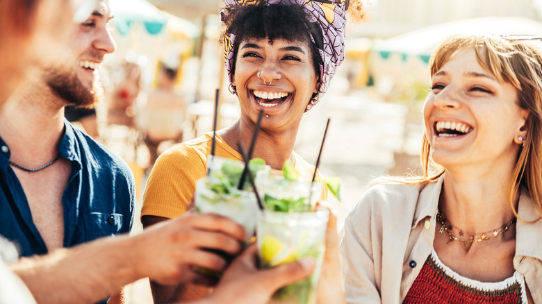 three people holding cocktails