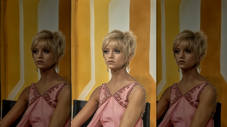 Goldie Hawn poses with a pixie cut and a pink dress