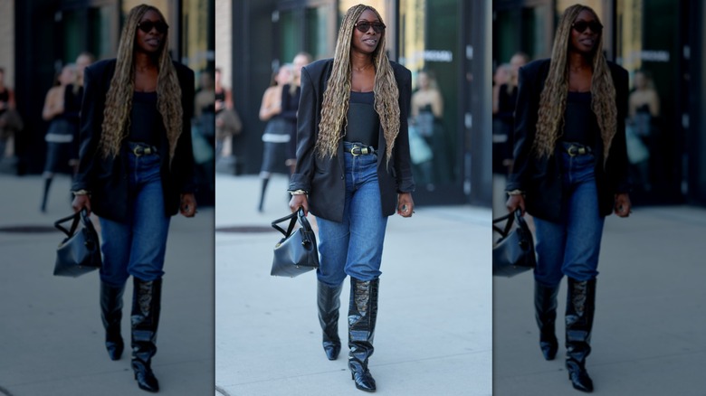 A woman wearing slouchy jeans with black boots