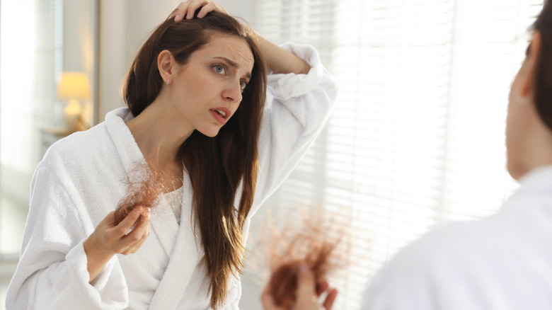 Woman looking at her hairline and losing hair
