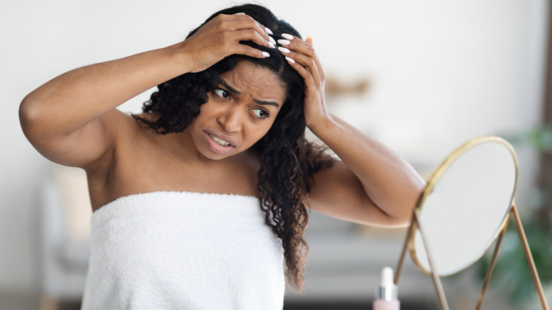 Woman examining her scalp