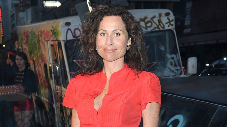 Minnie Driver smiling on the red carpet in an orange top in 2010