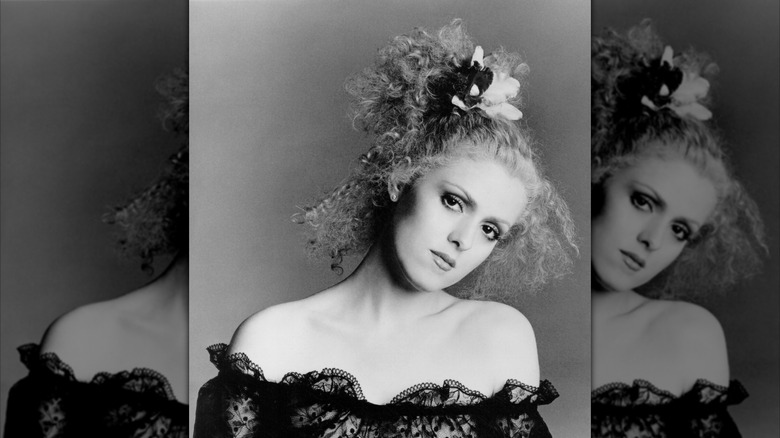 Black-and-white headshot showing a young Bernadette Peters posing in a studio in a black lace dress around 1970.