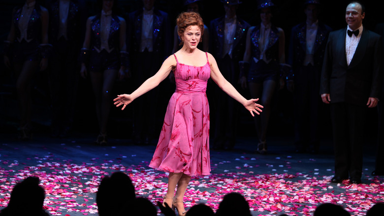 Bernadette Peters performing on stage in a pink dress in 2011.